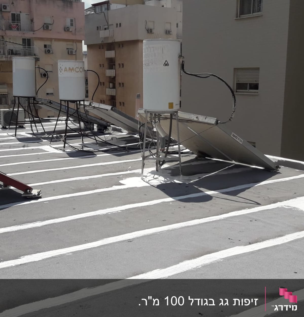 קווים לבנים של איטום על גג שטוח עם דודי שמש